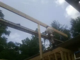 Carpenter setting a ridge beam over a new addition frame — Ice Dam Removal by Roofing Brothers in Lurgan